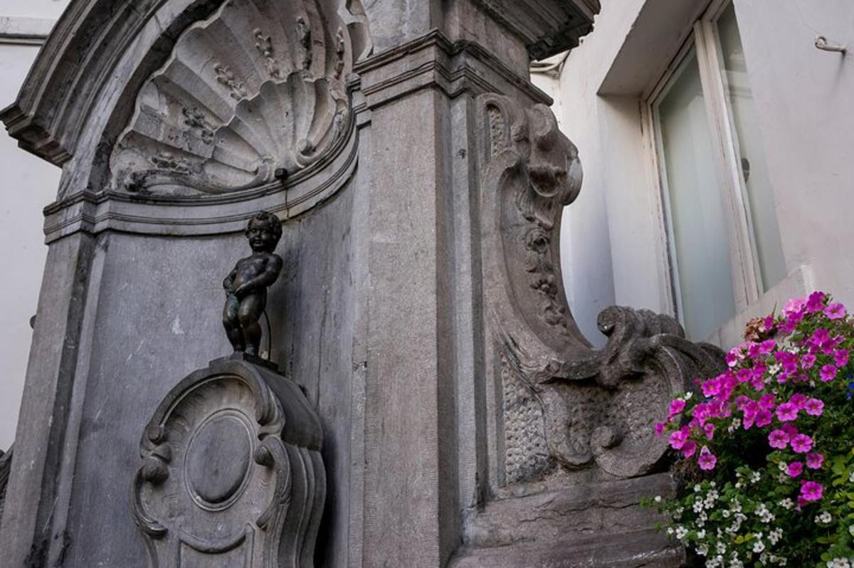 una estàtua al costat d'un edifici amb flors