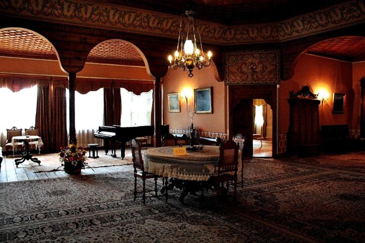 Una sala de estar con una mesa y un piano de cola.