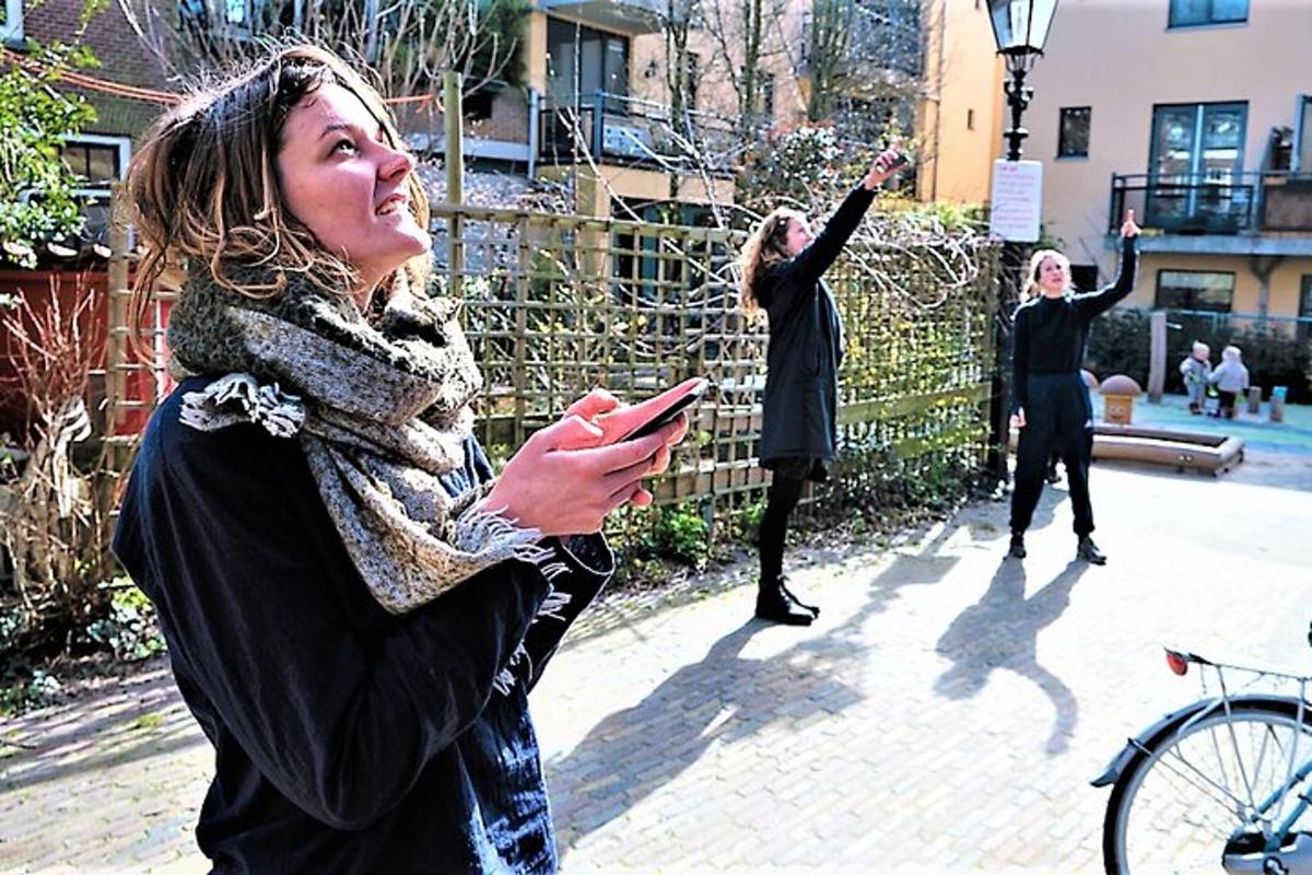 a group of women standing on a sidewalk looking at their cell phone
