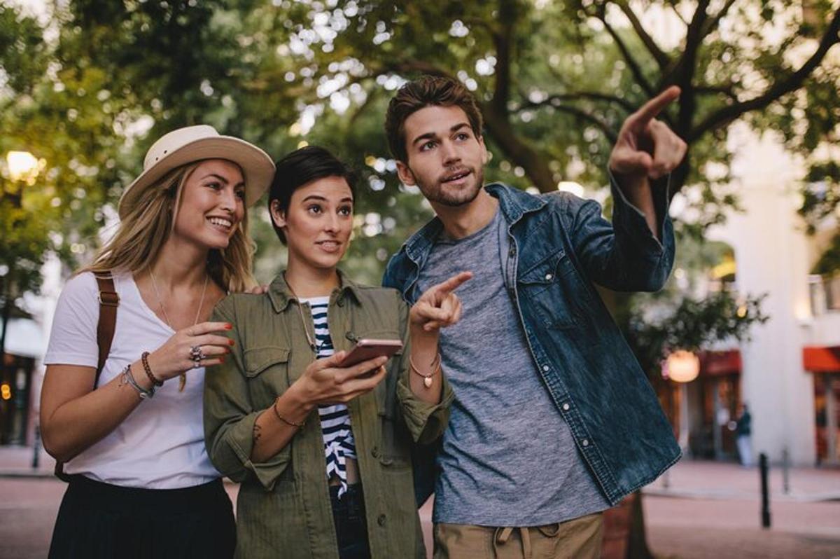 skupina tří lidí dívajících se na mobilní telefon