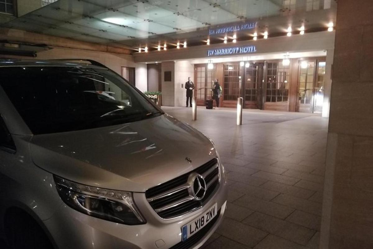 um carro prateado estacionado em frente a um prédio
