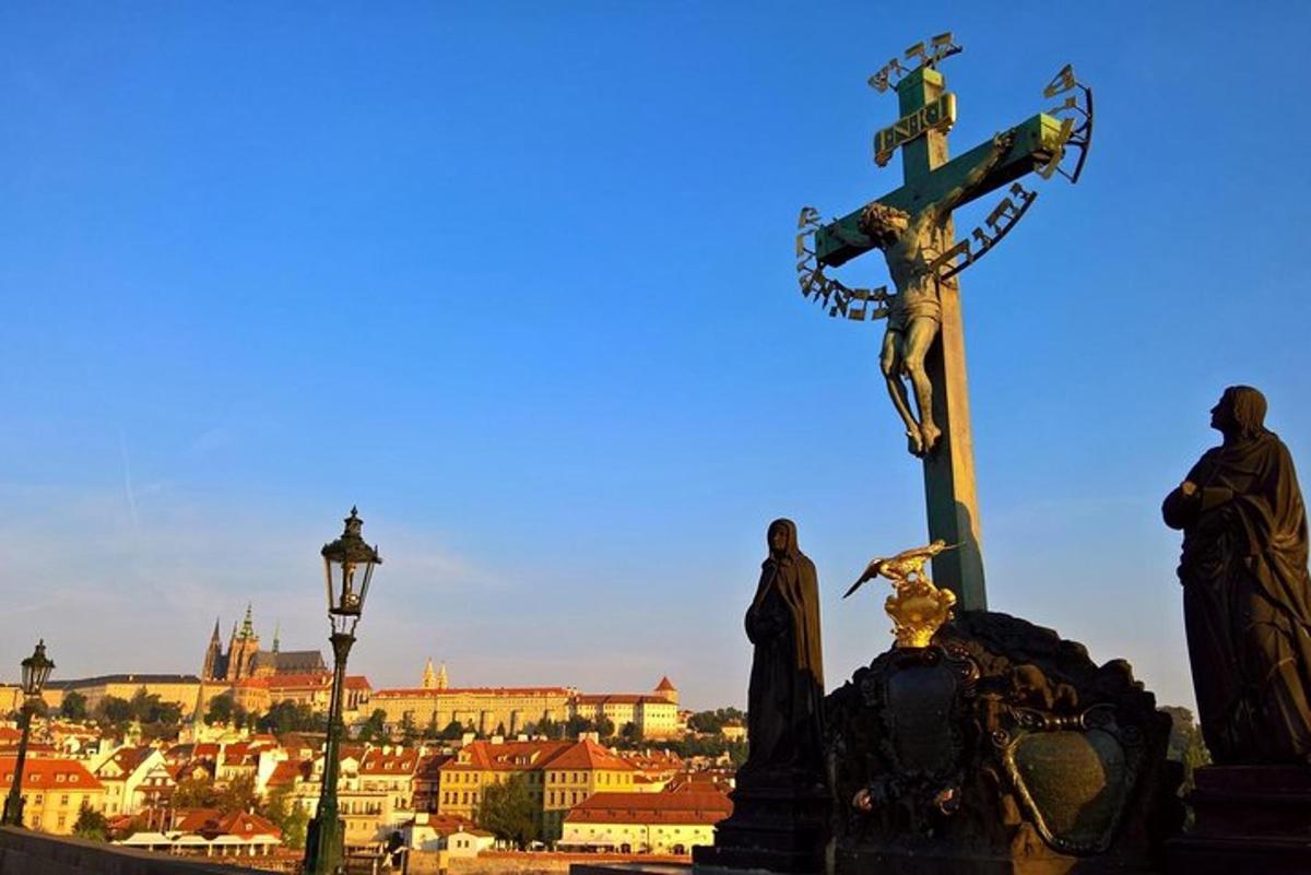 uma cruz no topo de uma estátua em frente a uma cidade