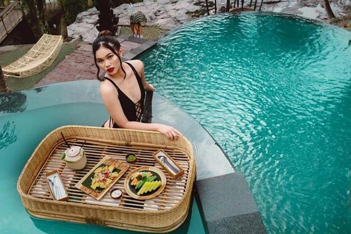 một người phụ nữ ngồi trên thuyền bên cạnh một hồ nước