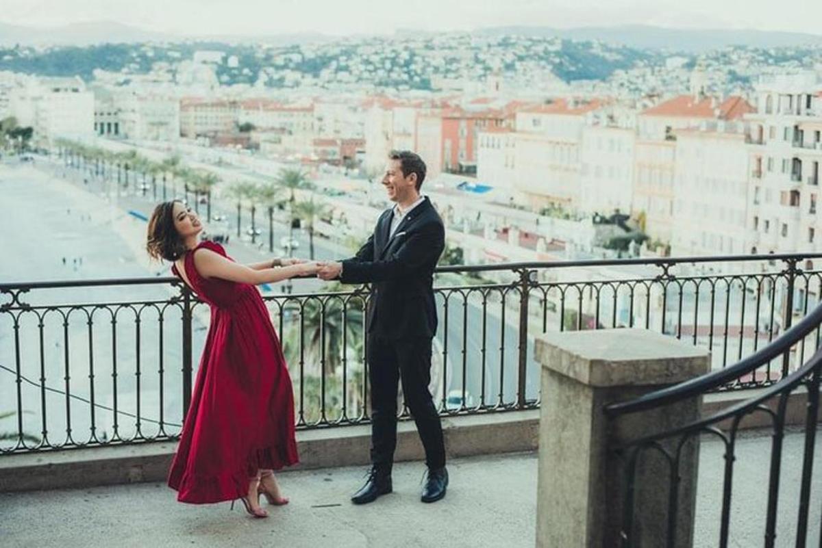 un homme et une femme se tenant la main sur un balcon