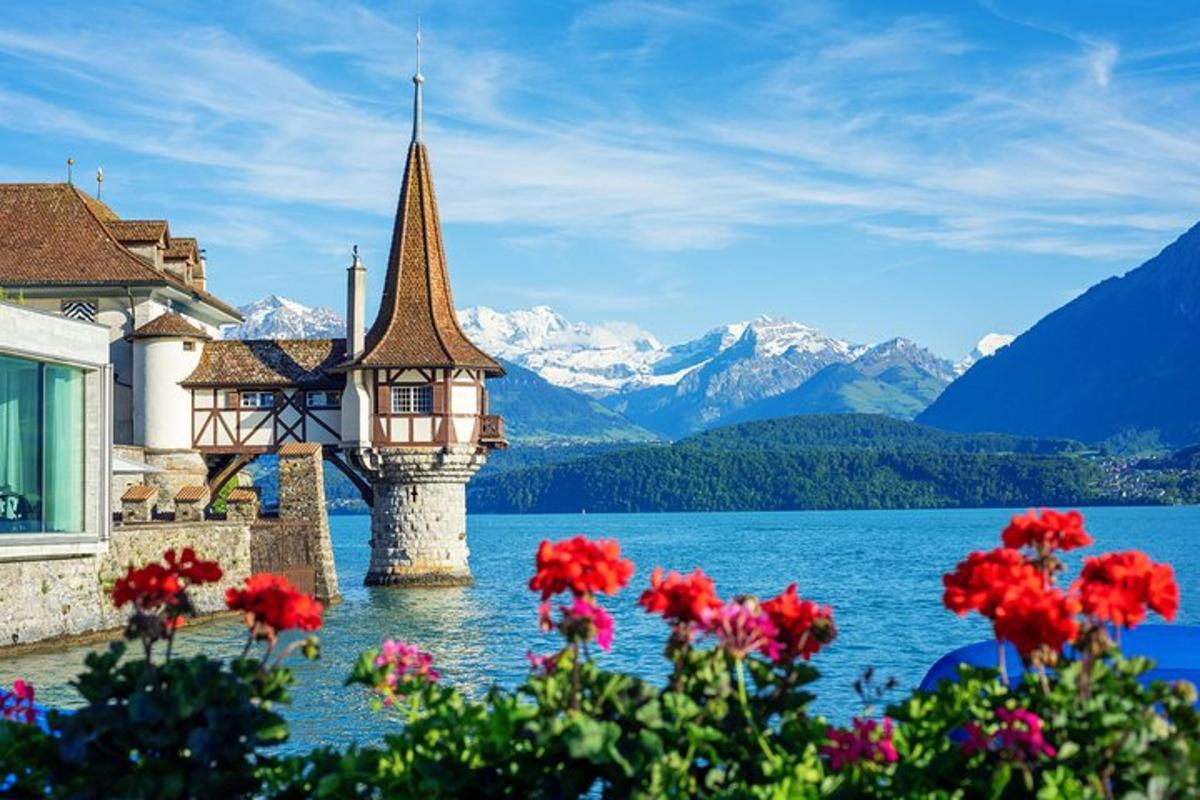 Una vista de un lago con una iglesia y flores.