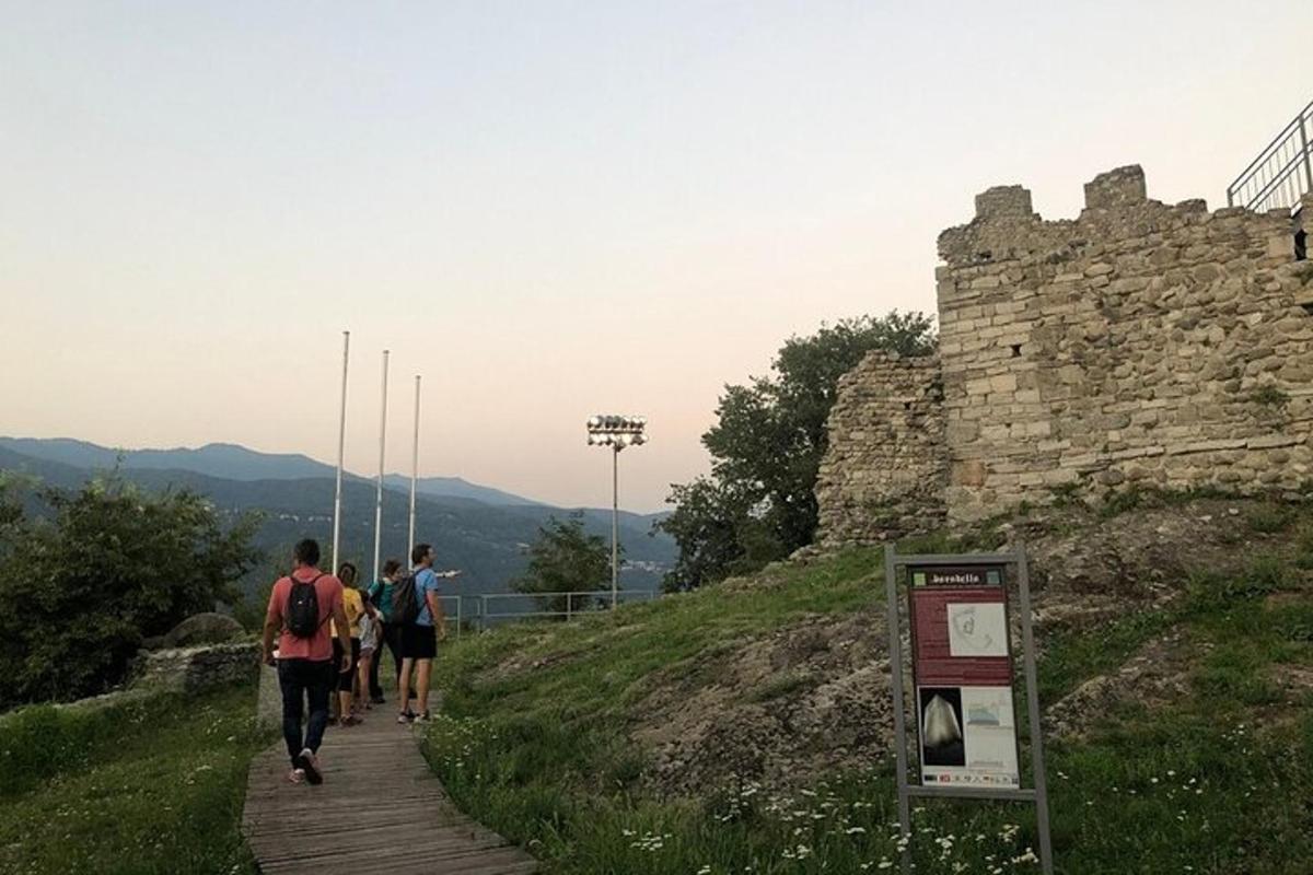un gruppo di persone che camminano su un sentiero vicino a un castello