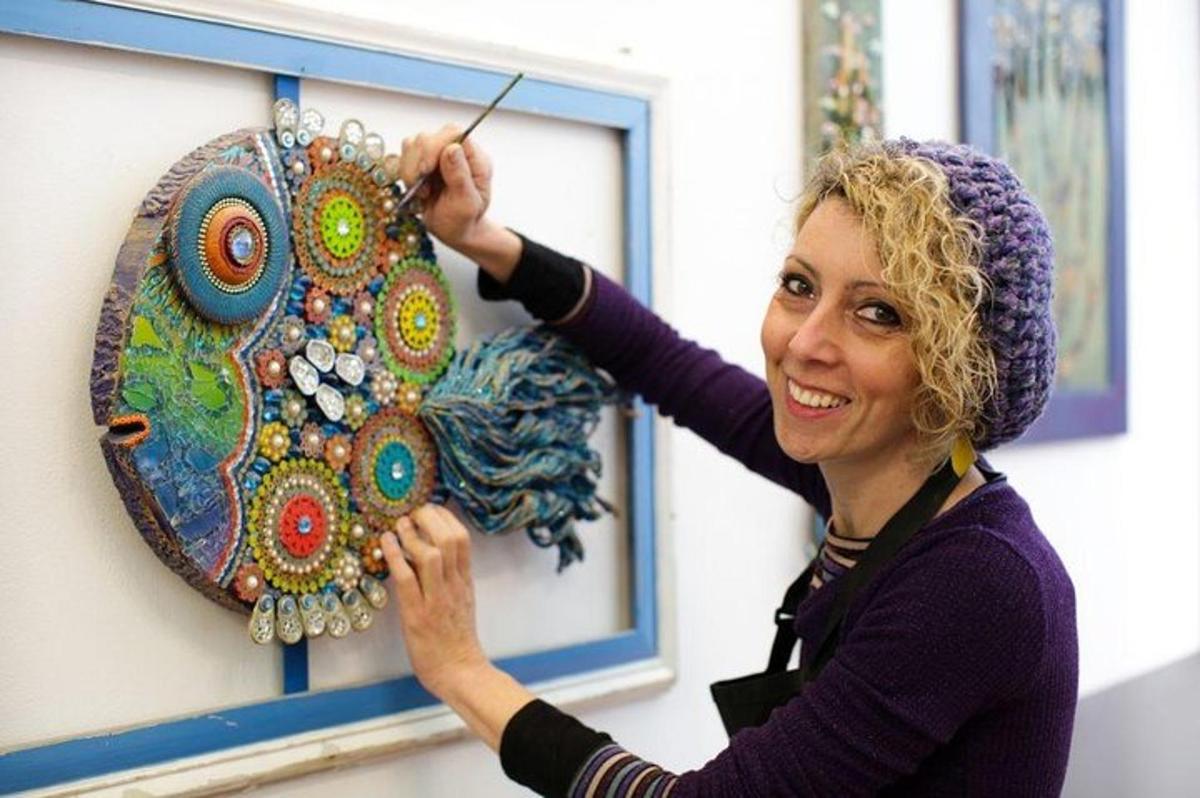 eine Frau arbeitet an einem Kunstwerk an einer Wand