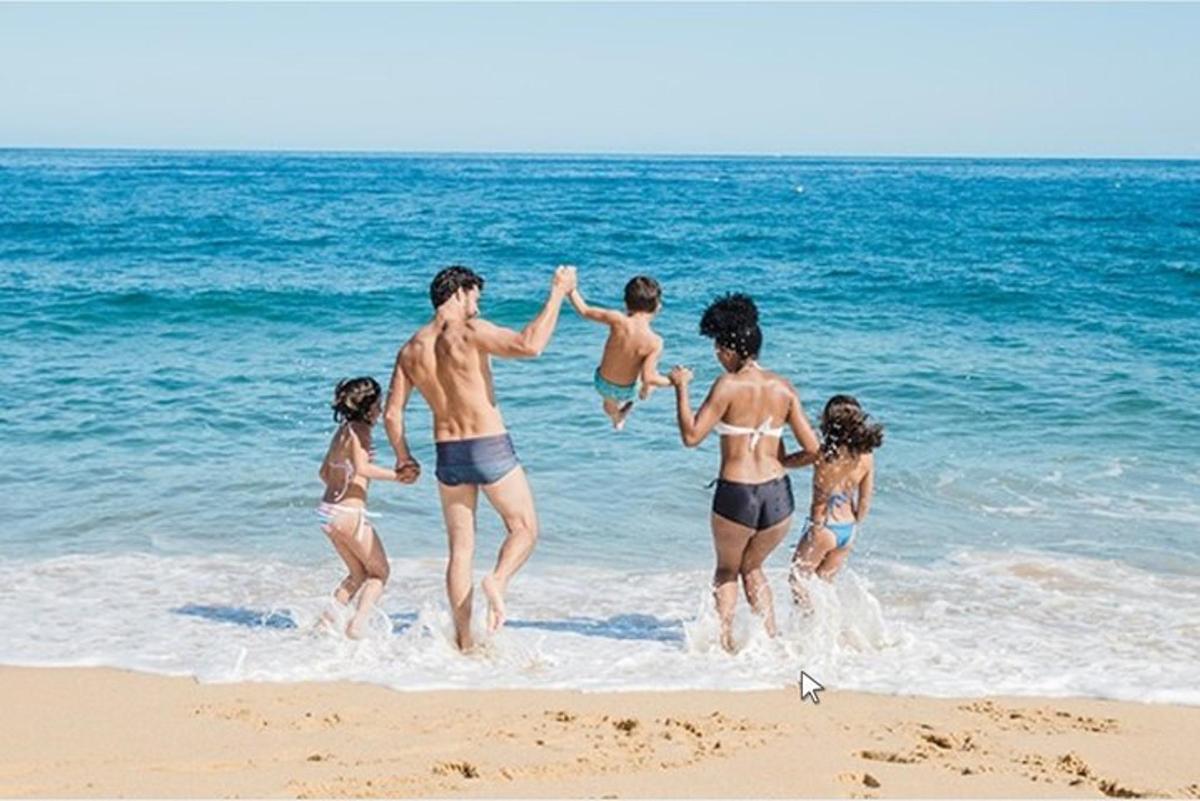 sekumpulan orang bermain air di pantai