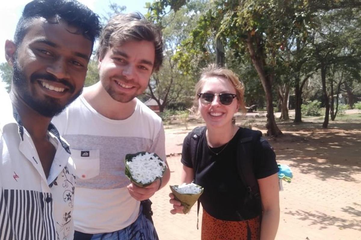 two men and a woman holding doughnuts in a park