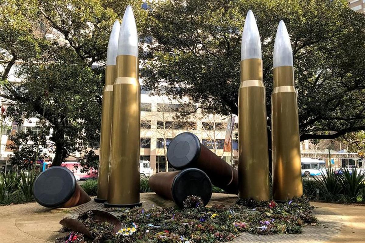 a statue of three rockets in a park