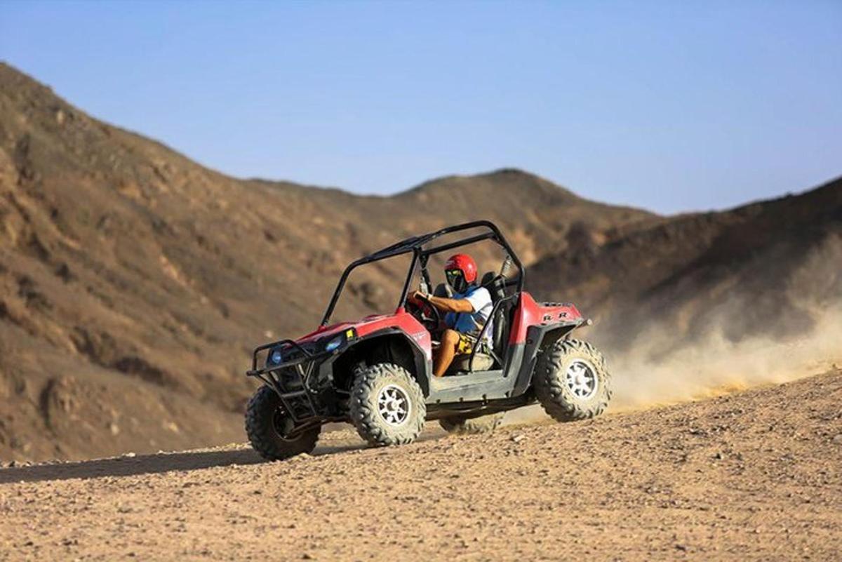 a person riding a red atv in the desert