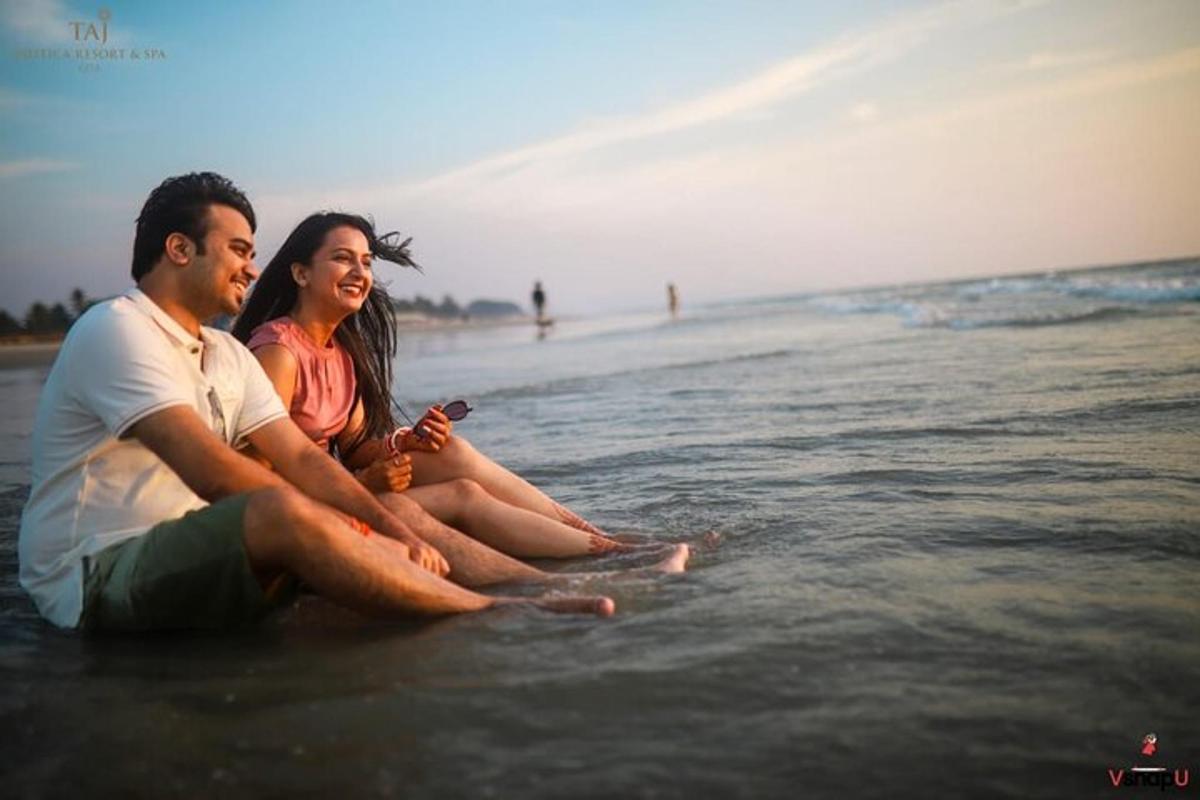 Un hombre y una mujer sentados en el agua en la playa