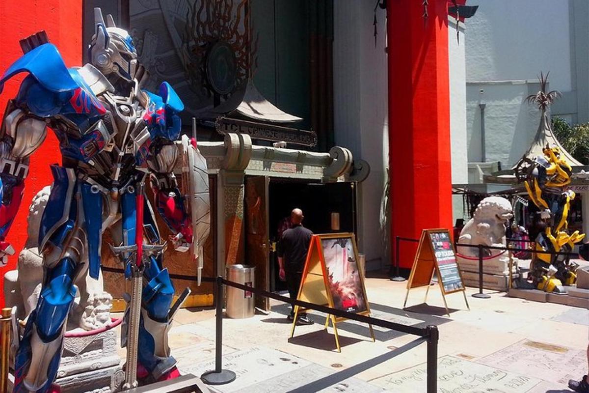 ein Mann steht neben einer Transformers-Statue