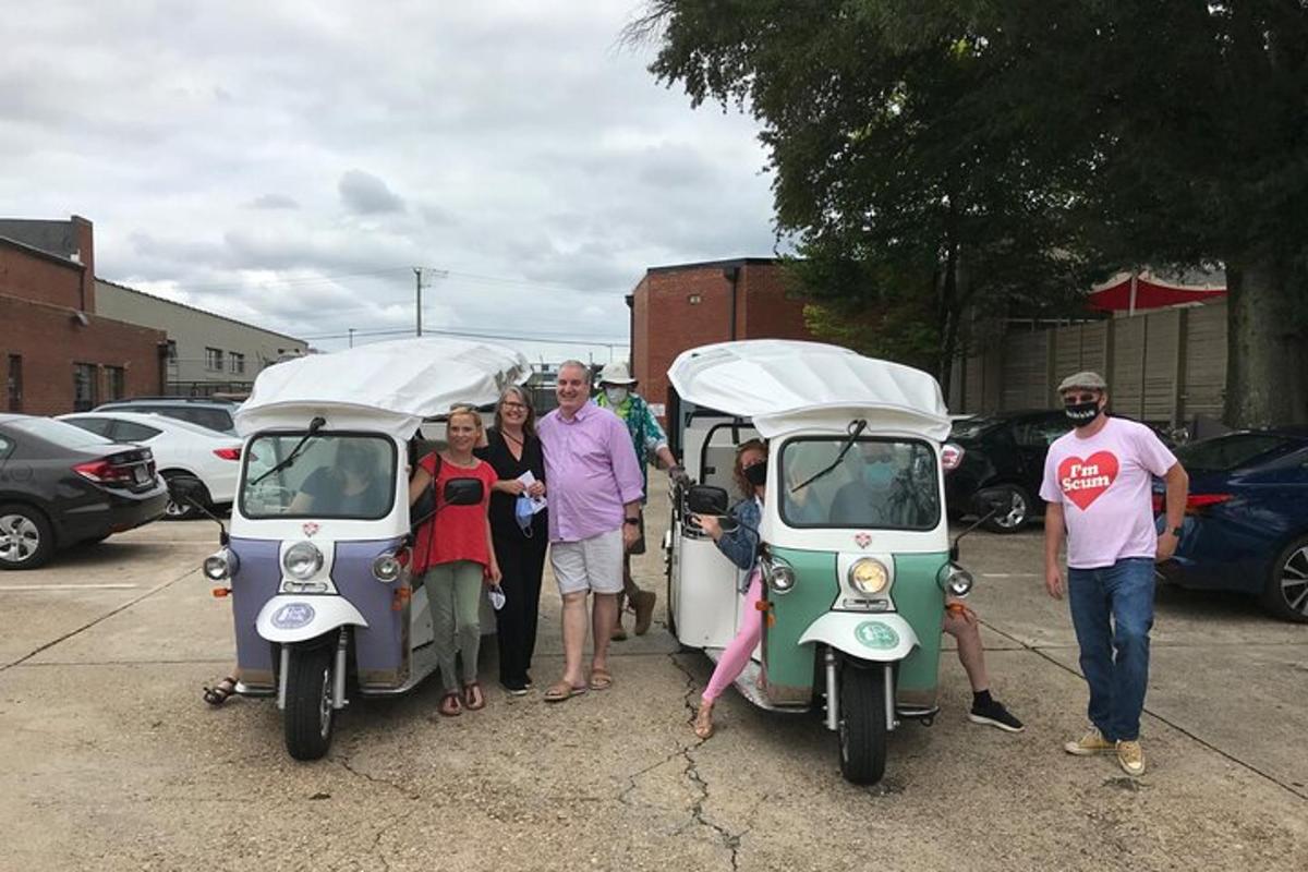 a group of people standing next to two small scooters