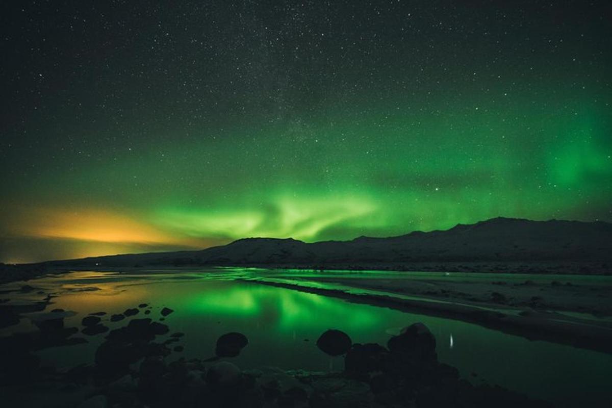 norðurljós yfir vatni að nóttu til