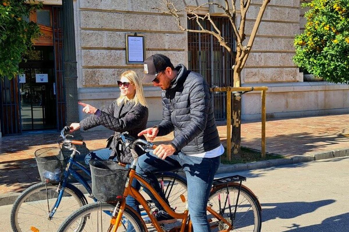 un uomo e una donna che vanno in bicicletta lungo la strada