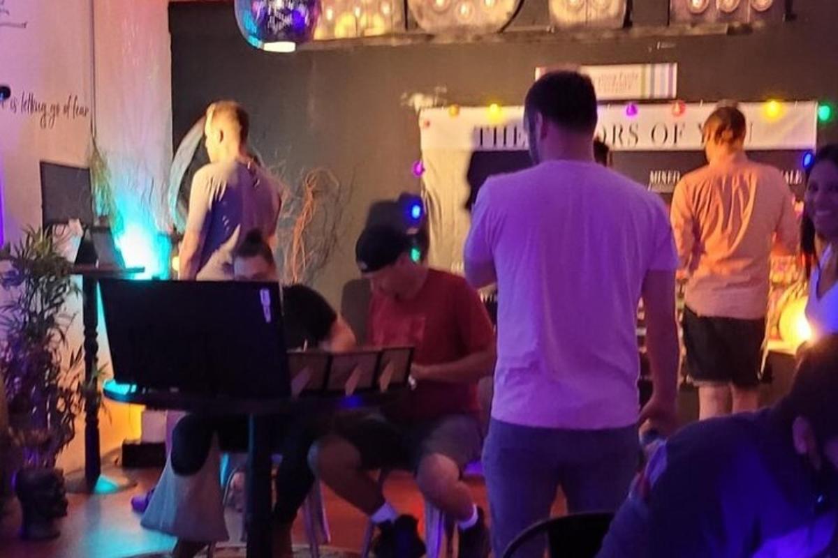 một nhóm người trong một căn phòng với một DJ