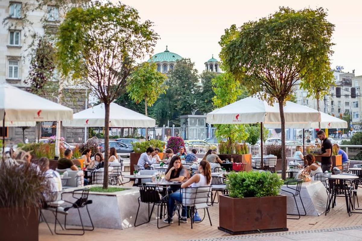 skupina lidí sedících u stolů ve venkovní restauraci