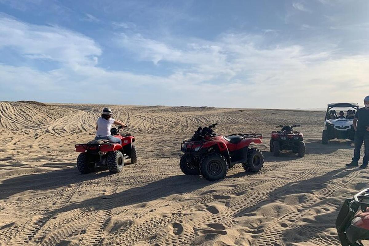 um grupo de pessoas andando de quadriciclo no deserto