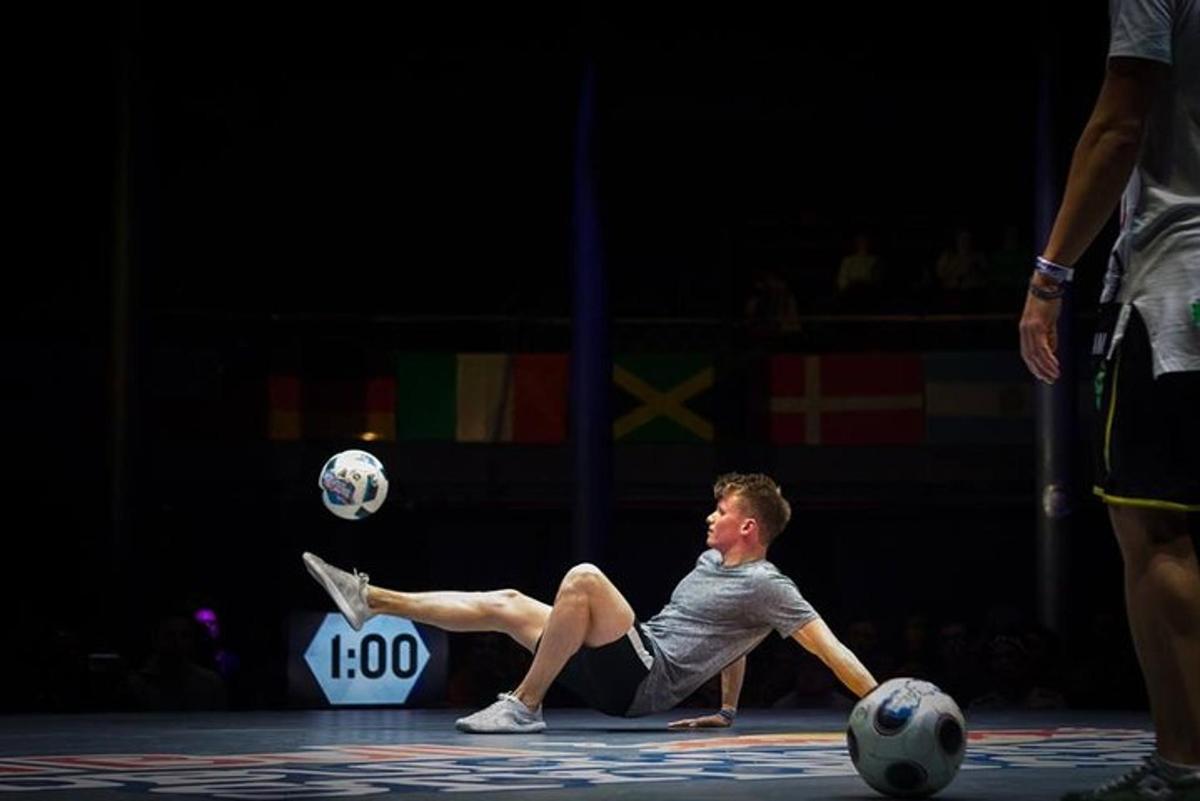 muž ležící na zemi na fotbalovém míči