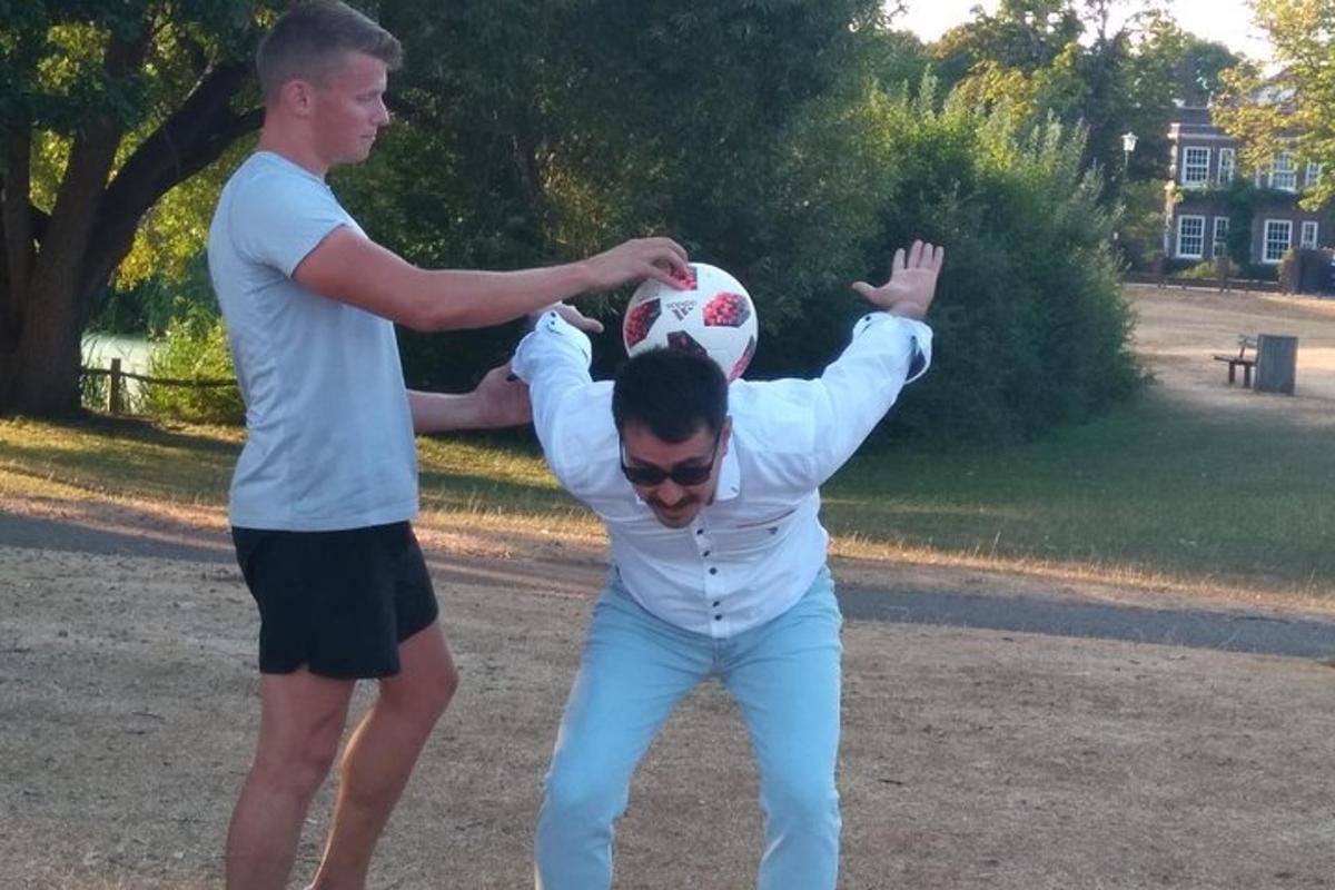 dva muži si hrají s fotbalovým míčem v parku