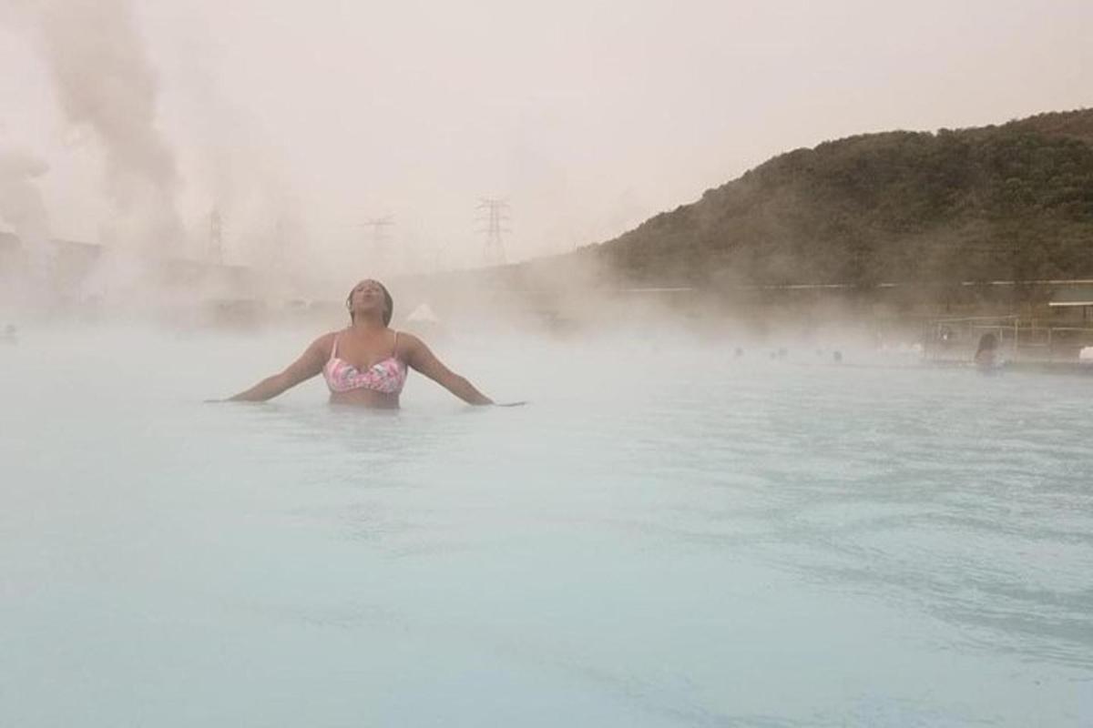 Kona stendur í vatninu í heitum laugum