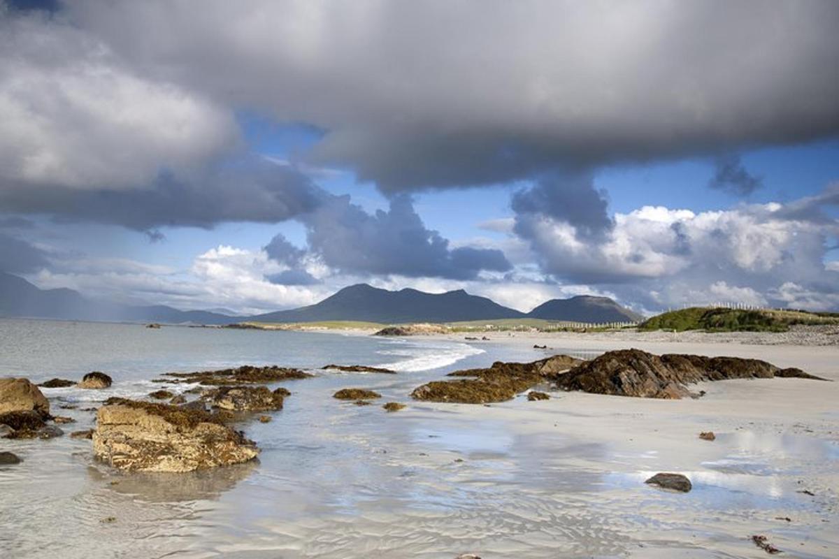 ein Strand mit Felsen im Wasser an einem bewölkten Tag