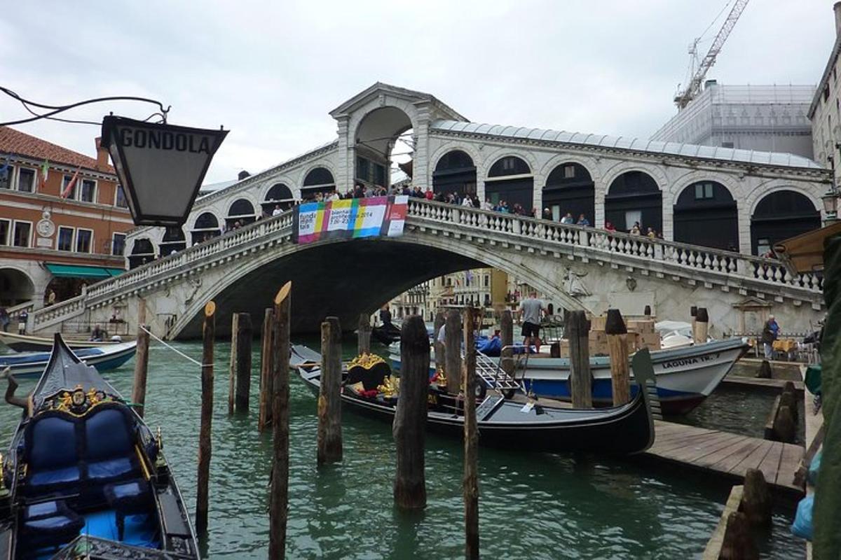 a bridge over a river with gondolas in the water