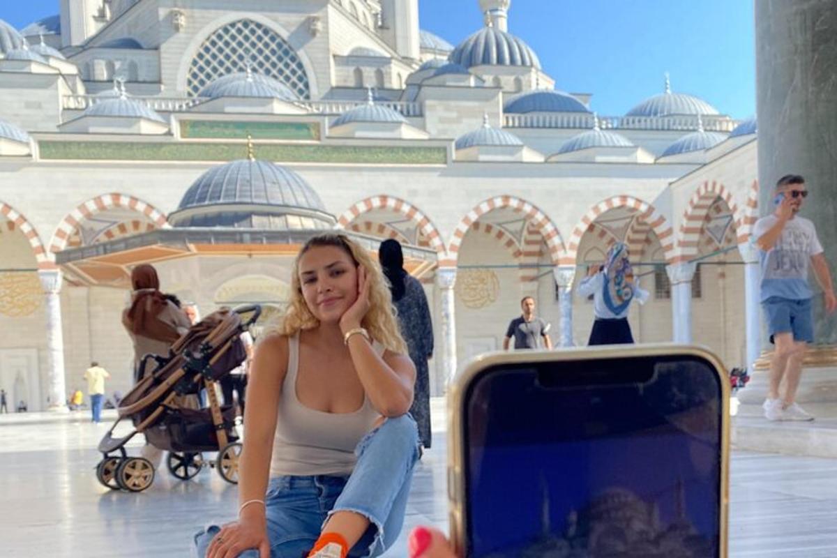امرأة تجلس على الأرض بجانب حقيبة سفر