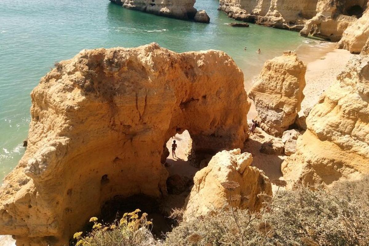 una platja amb gent nedant a l'aigua