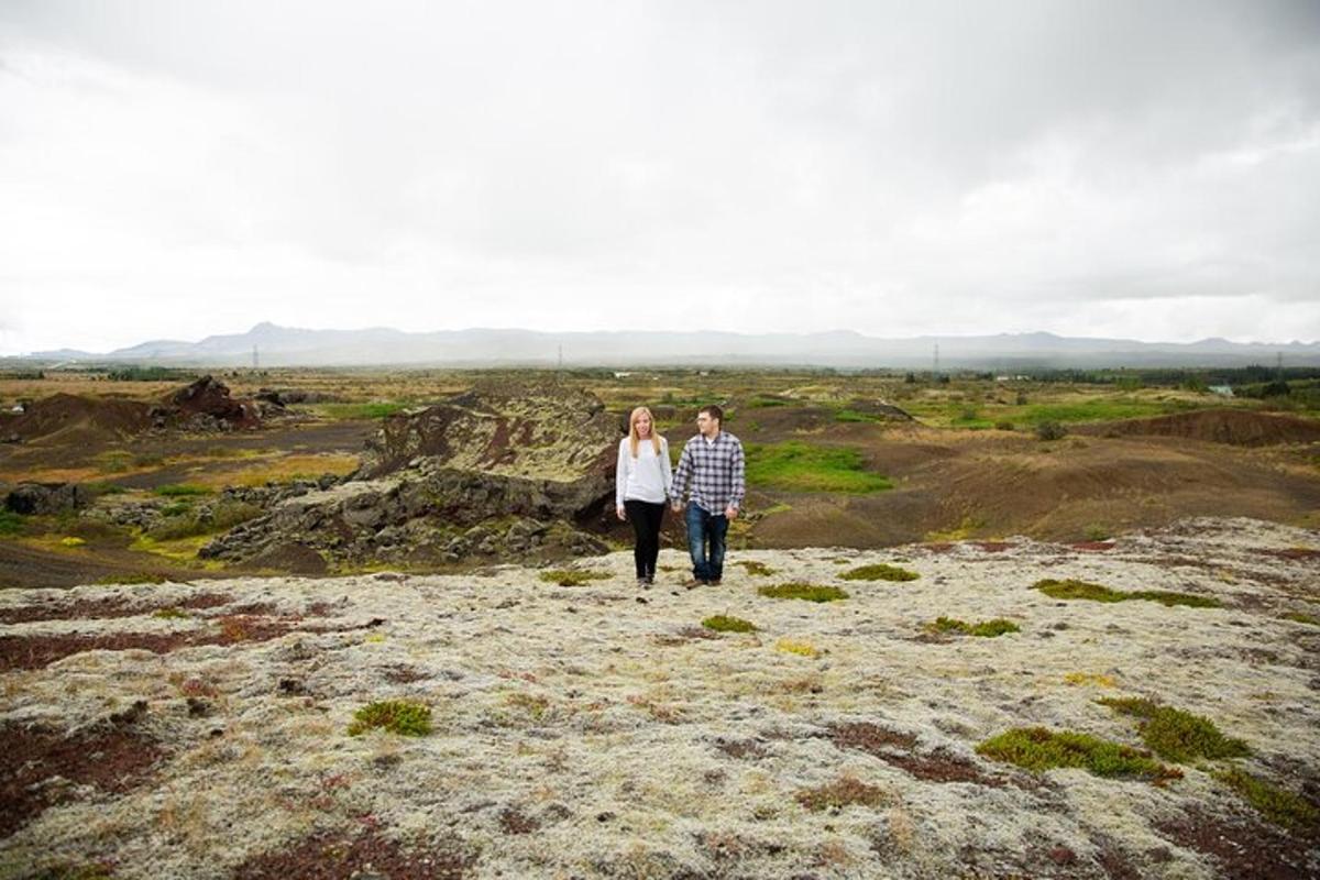 a man and woman walking on top of a hill