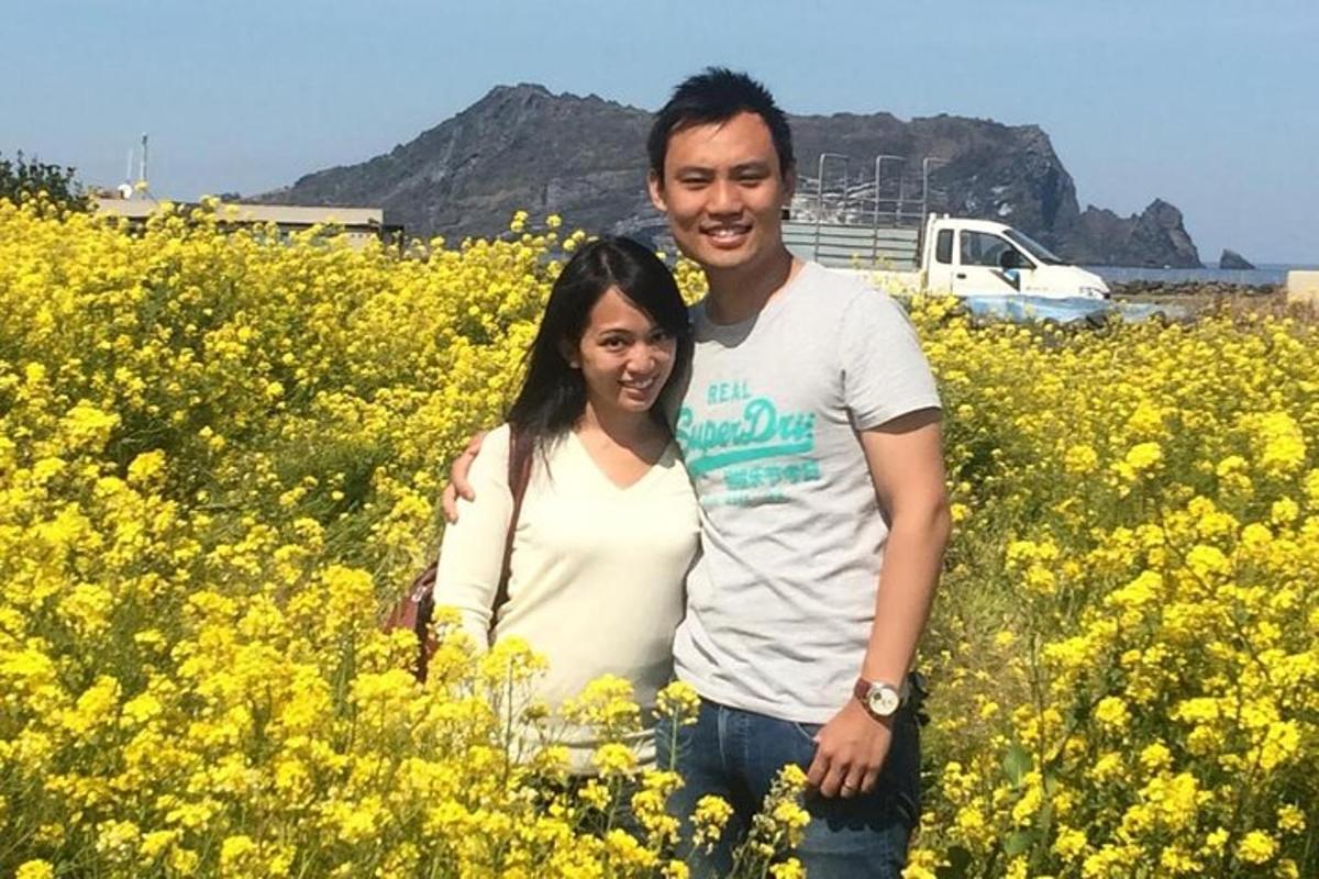 a man and a woman standing in a field of yellow flowers