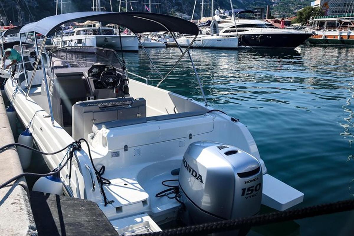 Un barco blanco atado a un muelle en el agua.