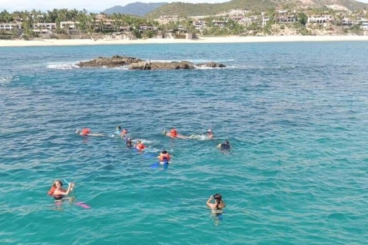 en gruppe mennesker som svømmer i havet
