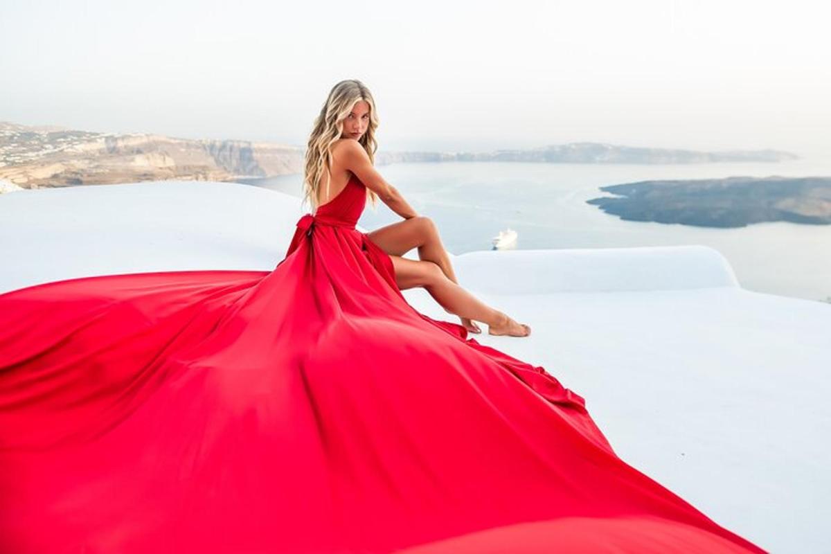 una mujer con un vestido rojo sentada en una roca