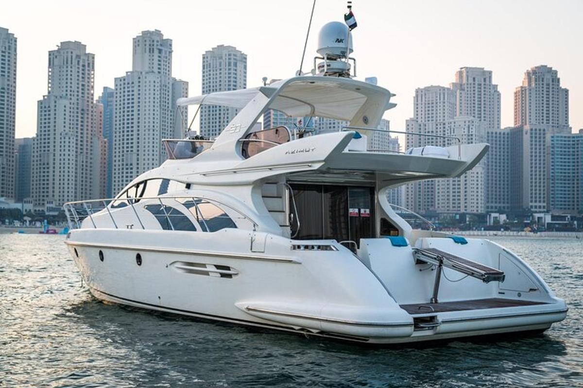 a white boat in the water with a city