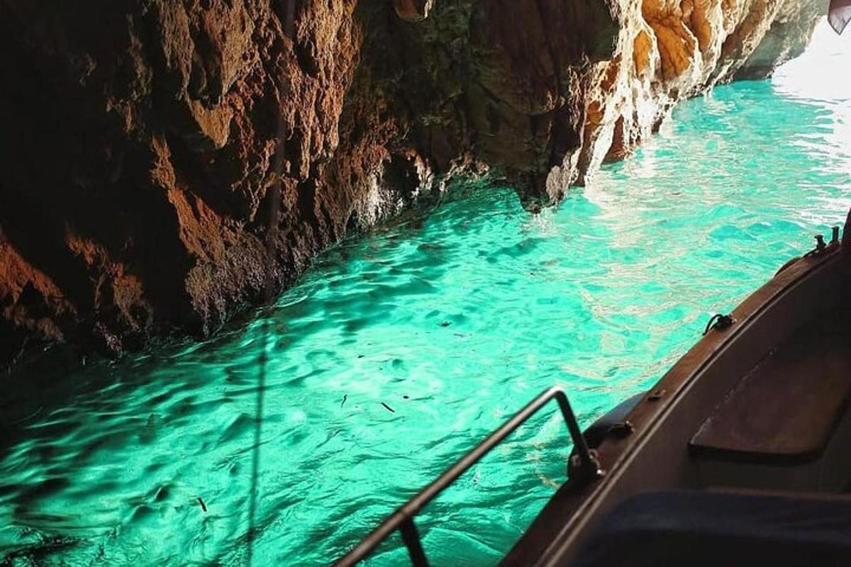 un barco en un cuerpo de agua junto a un acantilado