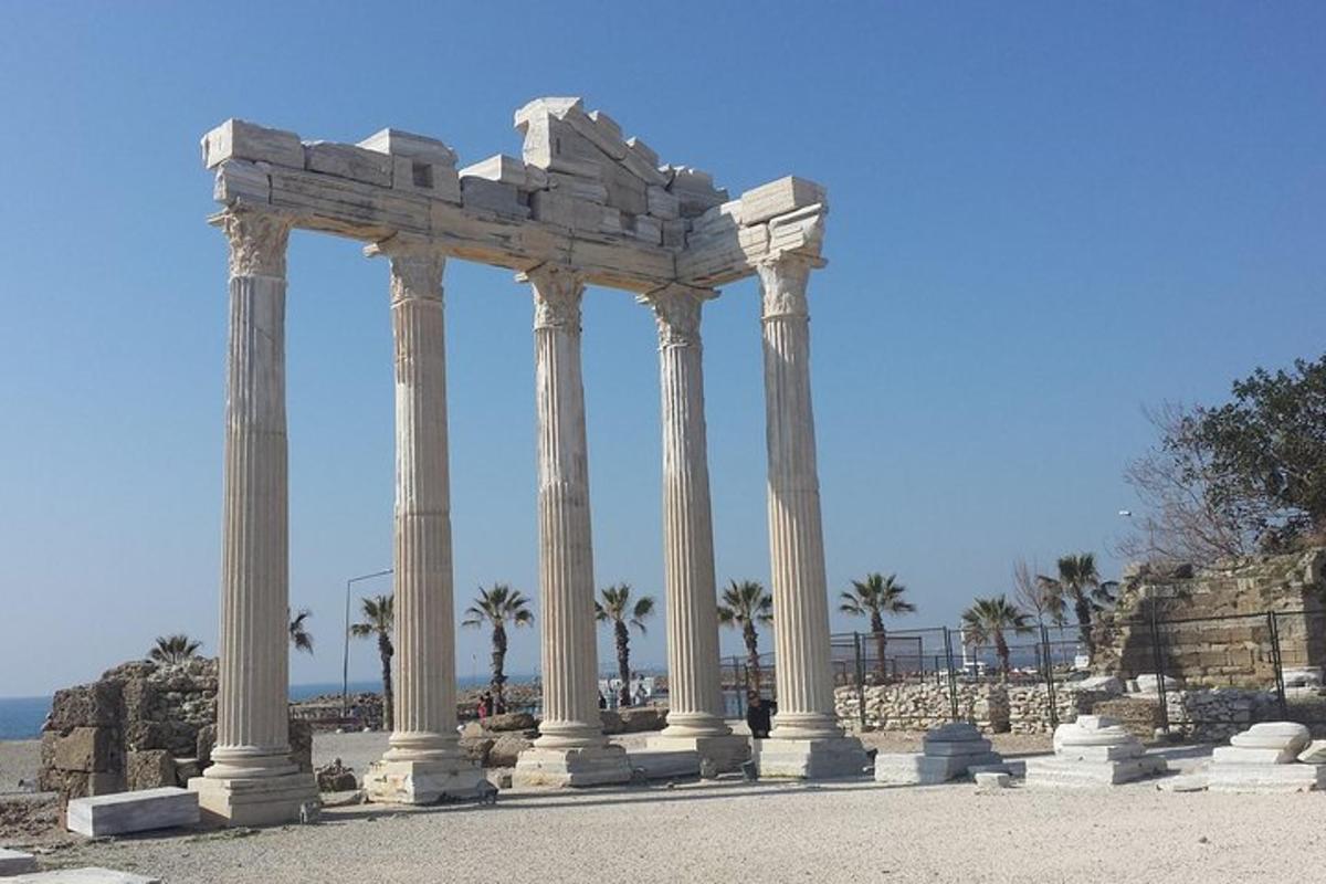 un gruppo di colonne di fronte a un edificio con palme