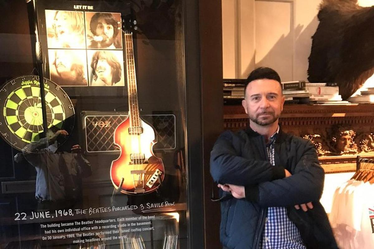 un uomo in piedi accanto a una chitarra in un negozio