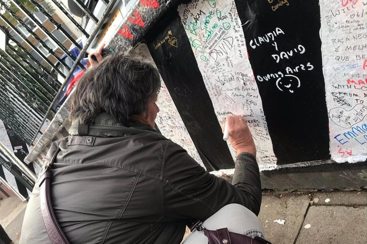 una donna seduta sul ciglio di un muro con graffiti