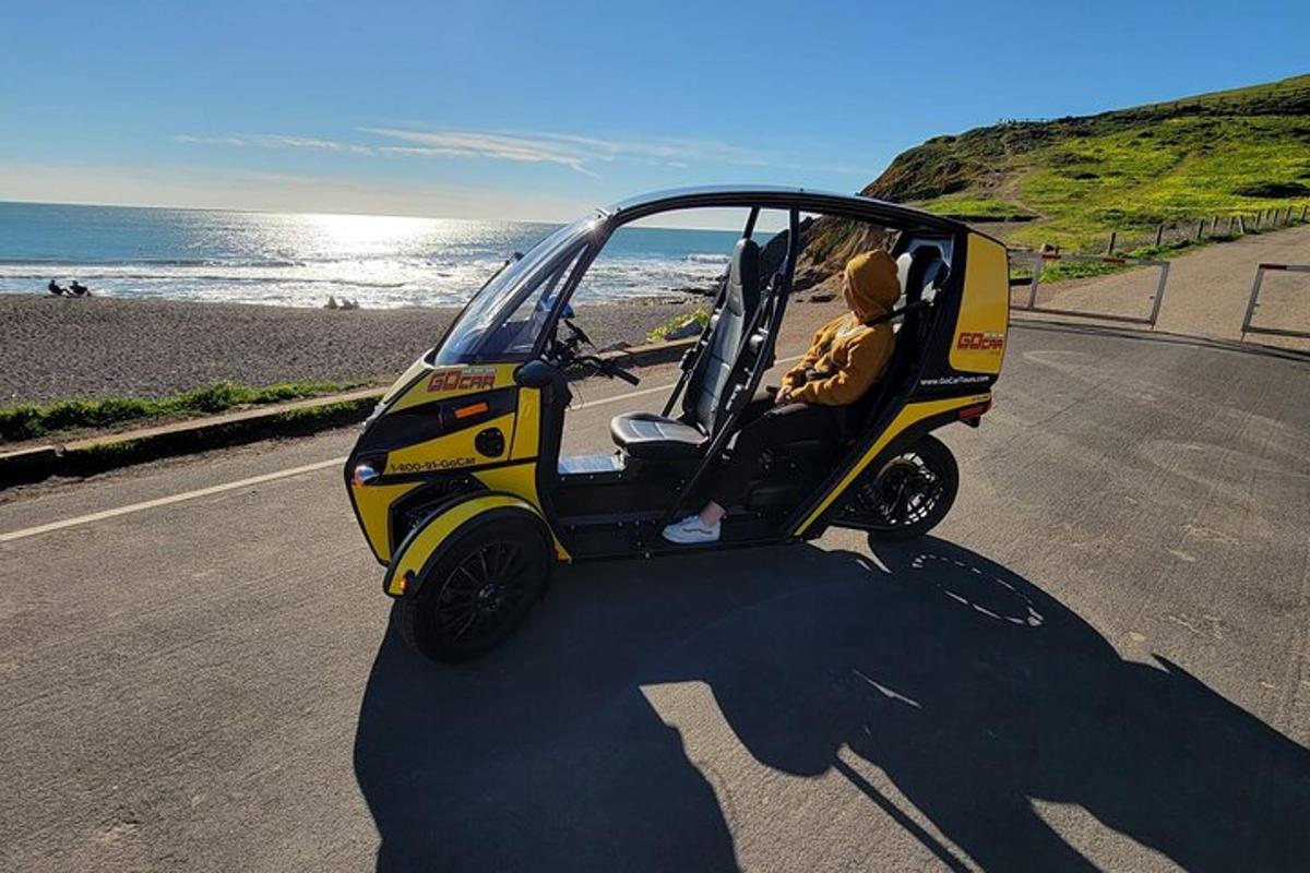 Un coche pequeño aparcado en una carretera cerca de la playa.