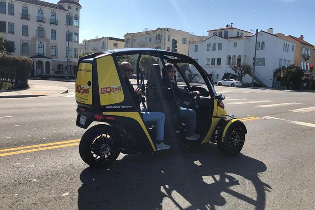 Dos personas viajando en un auto pequeño en la calle.