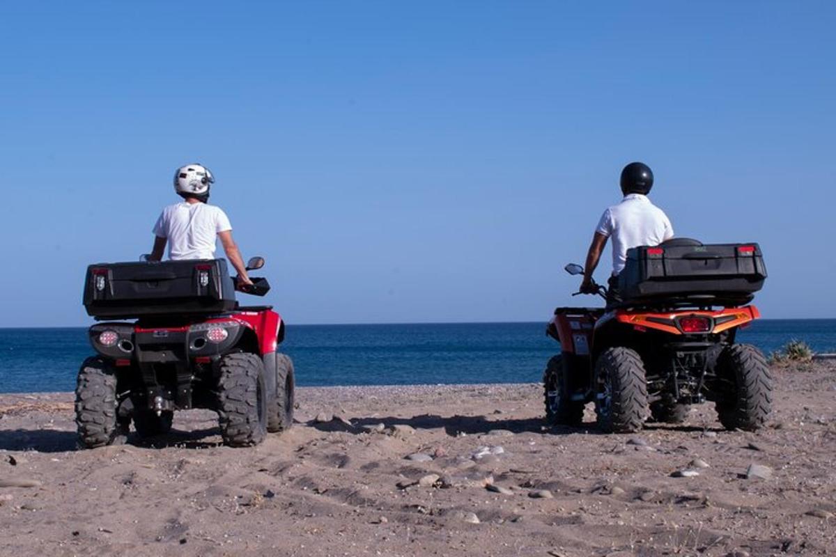 due uomini sono seduti su dei quad sulla spiaggia