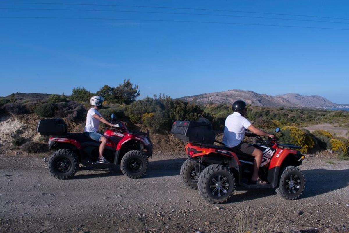dues persones que viatgen en quads per un camí de terra