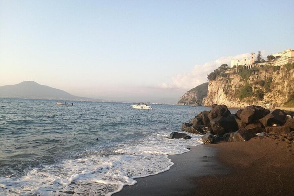 uma praia com pedras e água e um barco