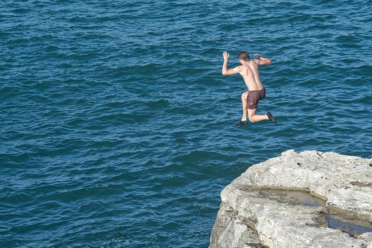muž skákající do vody v oceánu