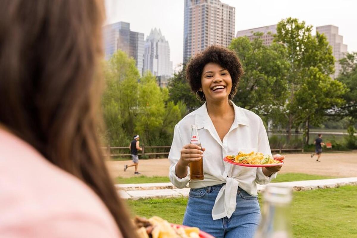 a woman holding a plate of food and a beer