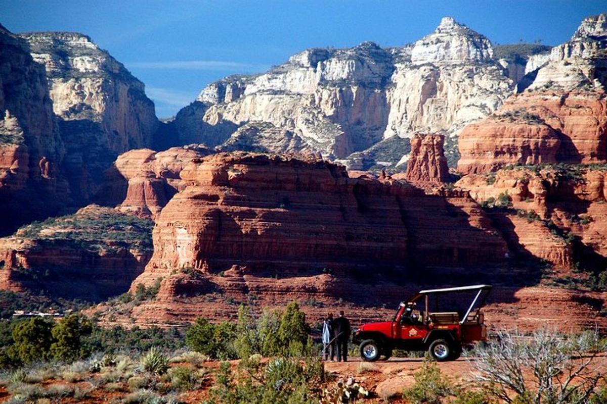 una jeep rossa parcheggiata davanti a un canyon