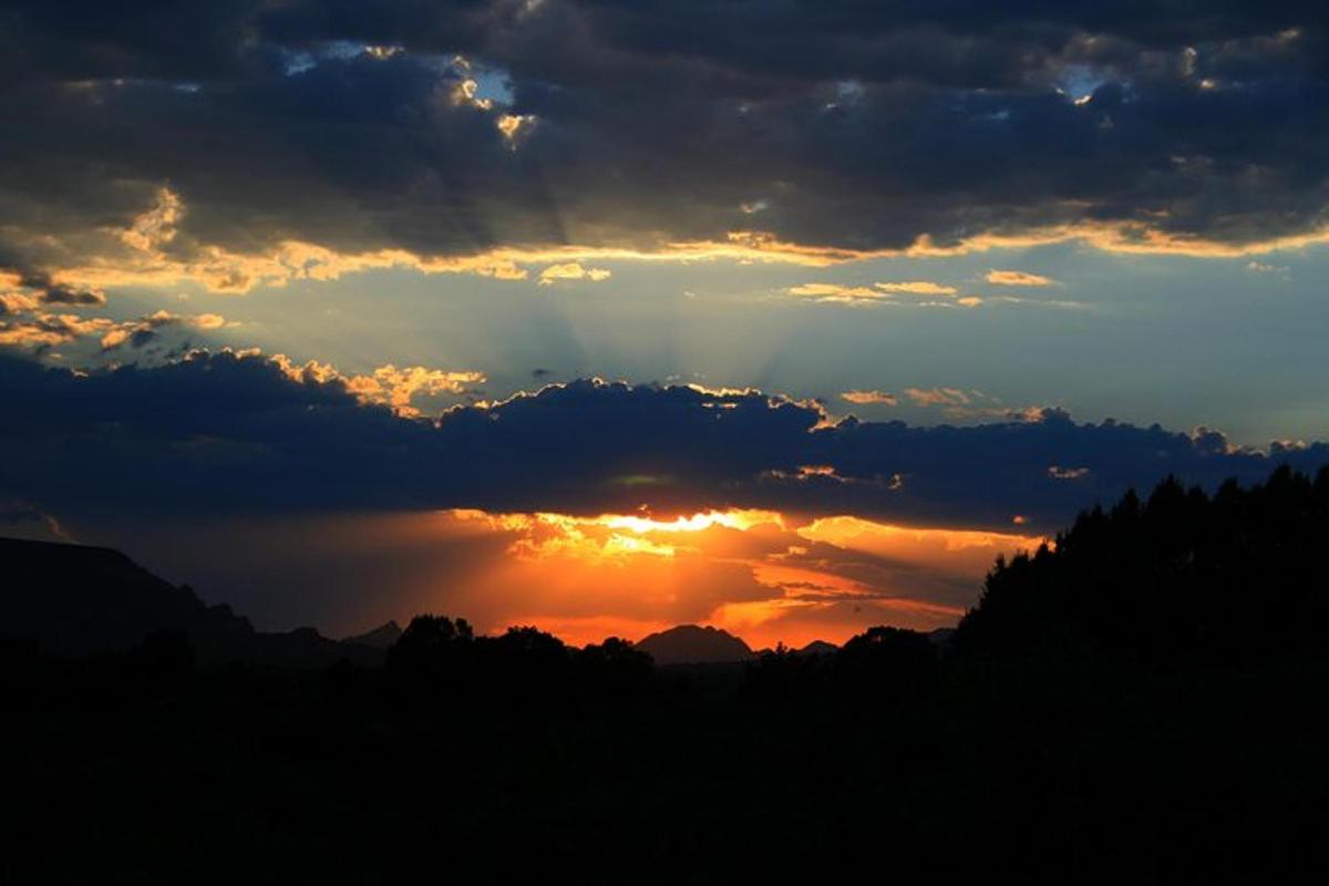 un tramonto con il sole che splende attraverso le nuvole