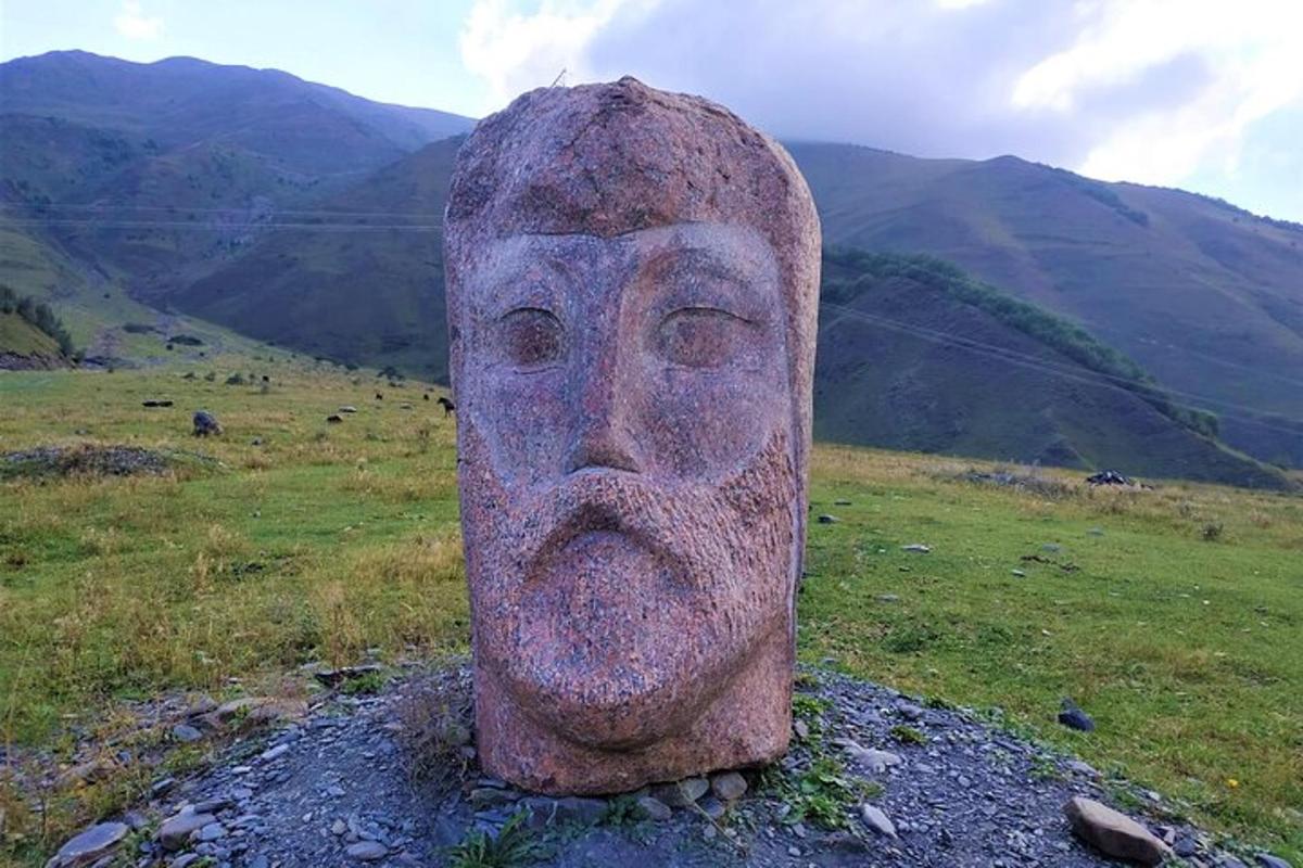 uma estátua de um rosto no topo de uma colina